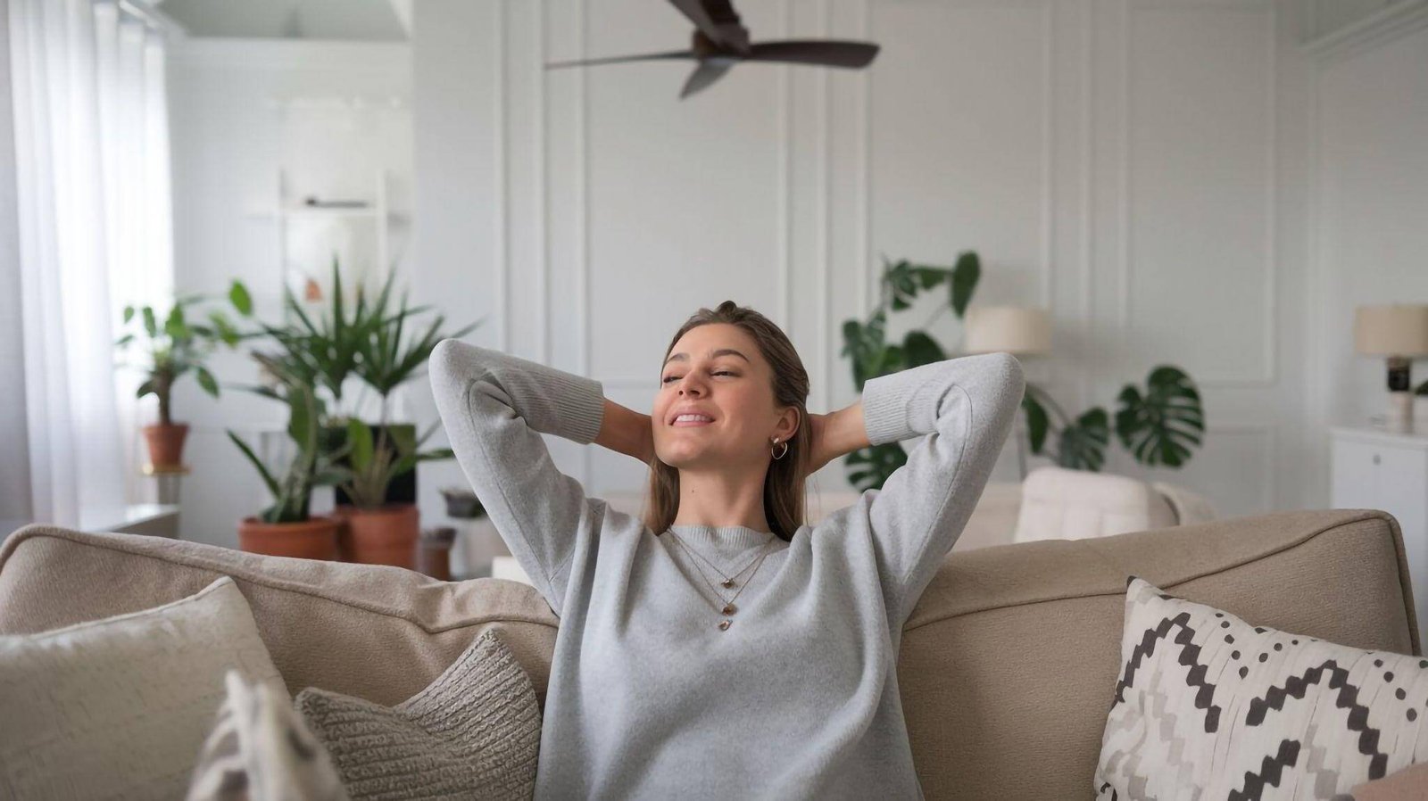 Mulher relaxando no sofá de casa.